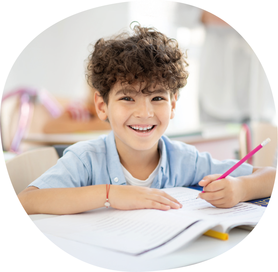 Ein Junge schreibt in ein Schulheft.