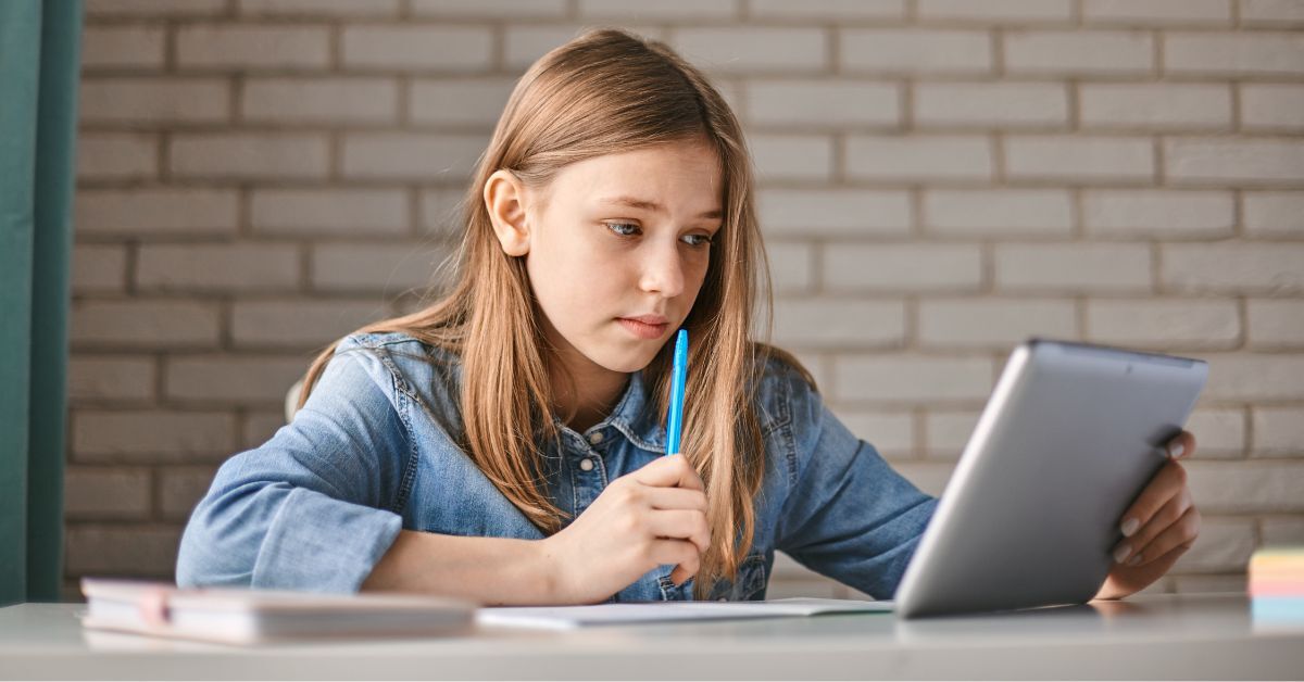 Ein Teenager-Mädchen macht ihre Hausaufgaben an einem Tablet.