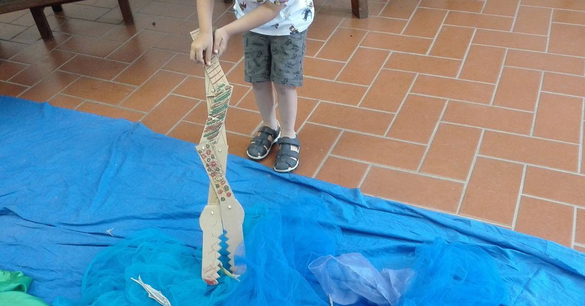 Ein Junge spielt mit dem selbst gebastelten mechanischen Krokodil.